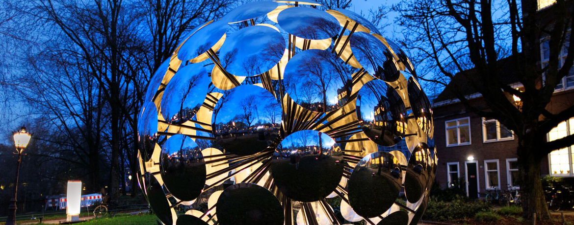 ORB glowing luminous sphere artwork by SpY illuminating Amsterdam canal water during Amsterdam Light Festival