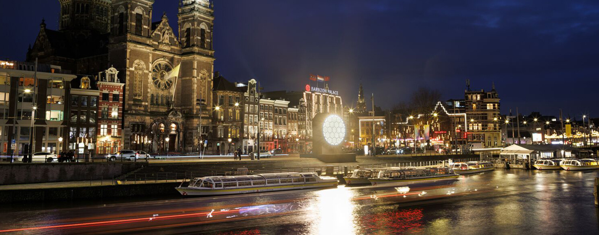 The Sun circular warm light installation by Zenisk suspended above an Amsterdam canal bridge