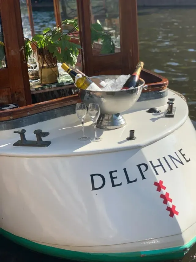 Stern of the boat Delphine with a silver champagne bucket and glasses on the rear deck