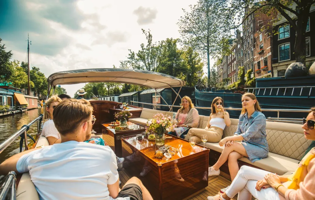 Guests seated on the lounge seating of Pure Spirit on an Amsterdam canal