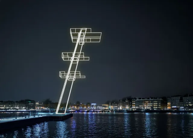 Illuminated white-outlined diving tower sculpture beside the Amstel at night, Amsterdam skyline reflected in dark water