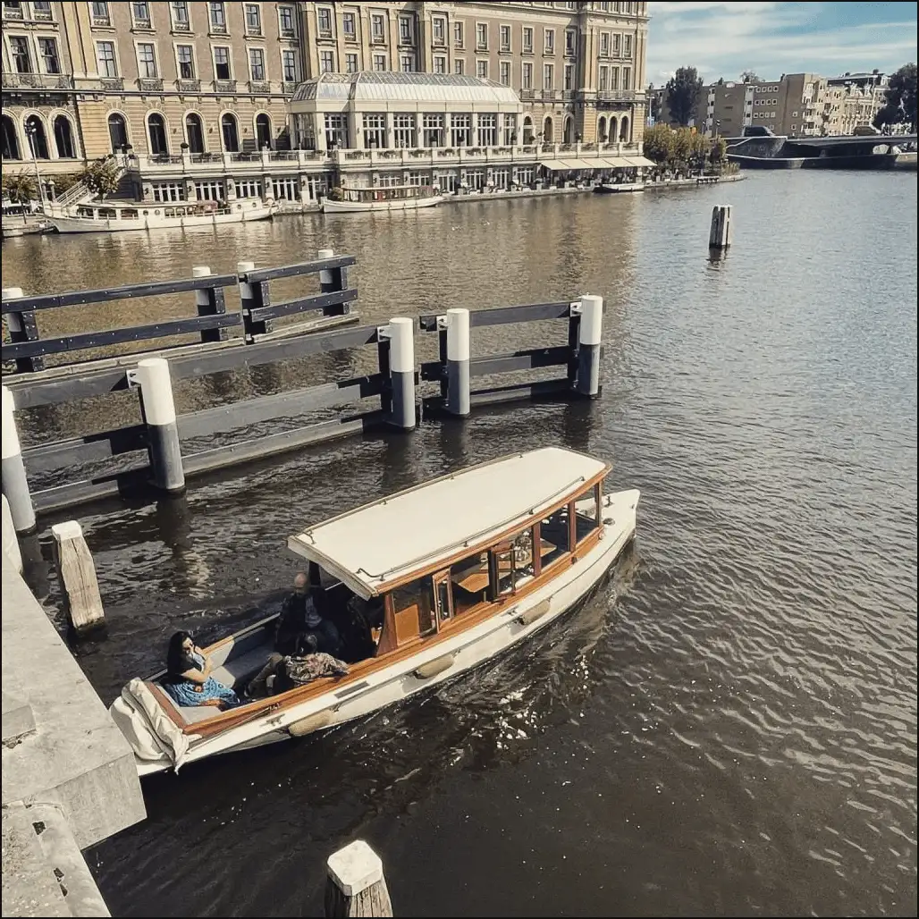 Private luxury saloon boat cruising an Amsterdam canal